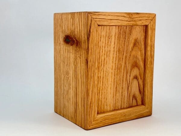 A wooden box with a small hole in the middle.