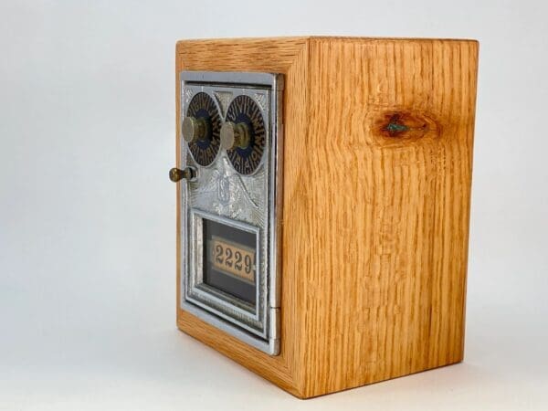 A wooden box with a metal door and two knobs.