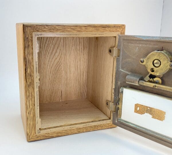 Wooden box with metal lock, partly open.