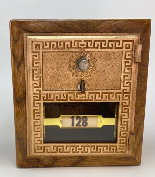 A wooden box with a clock and key on top of it.