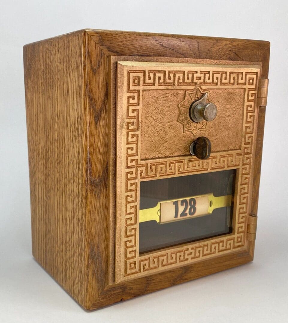 A wooden box with a key and a small number plate.