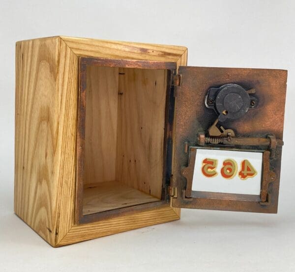 A wooden box with an open door and a picture frame.