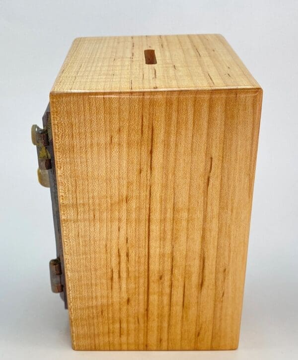 A wooden box with a metal handle on top.