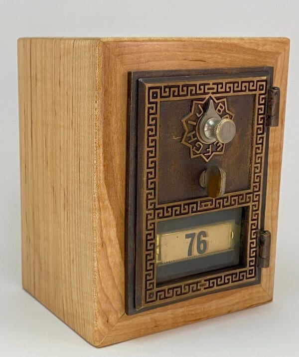 A wooden box with a clock and number 7 6 on it.