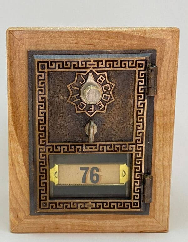 A wooden box with a clock and number 7 6 on it.