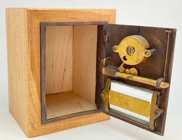 A wooden box with an open door and some metal parts