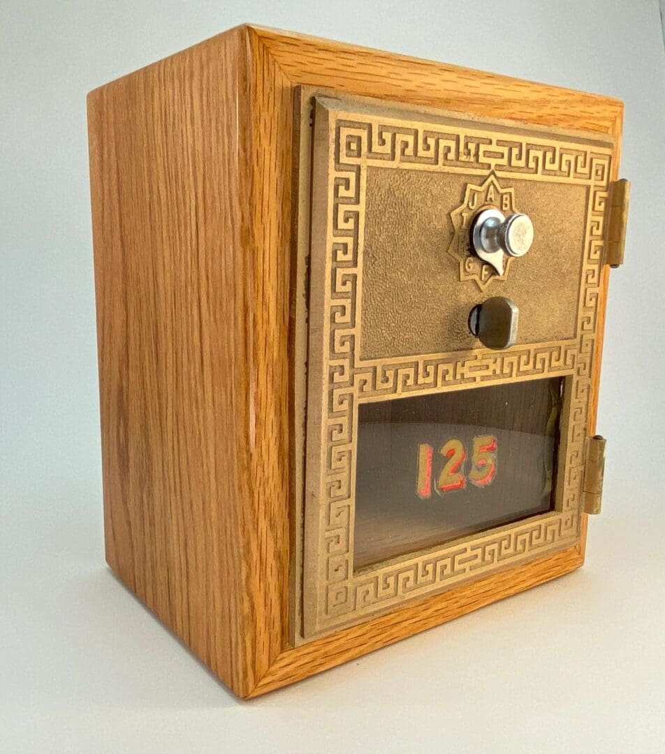 A wooden box with a door and the number 1 2 5 on it.