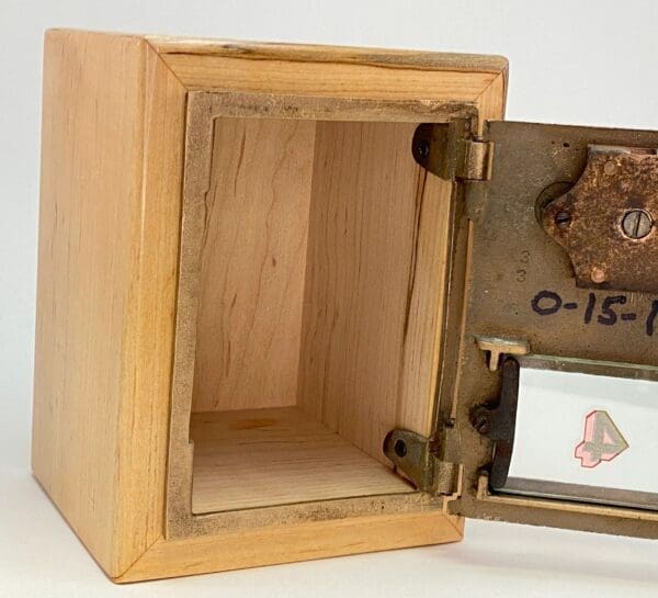 A wooden box with a metal door and a lock.