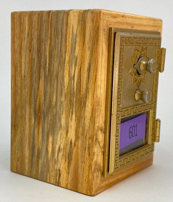 A wooden box with a small gold and purple door.