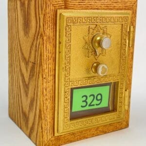 A wooden box with a gold door and the number 3 2 9.