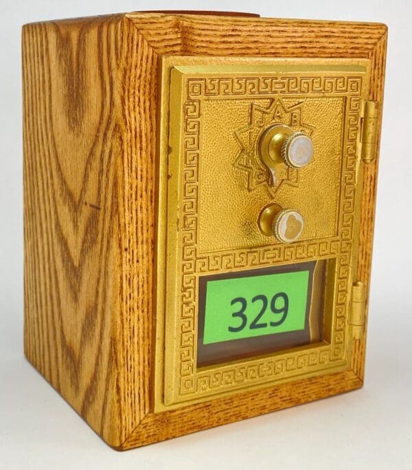 A wooden box with a gold door and the number 3 2 9.