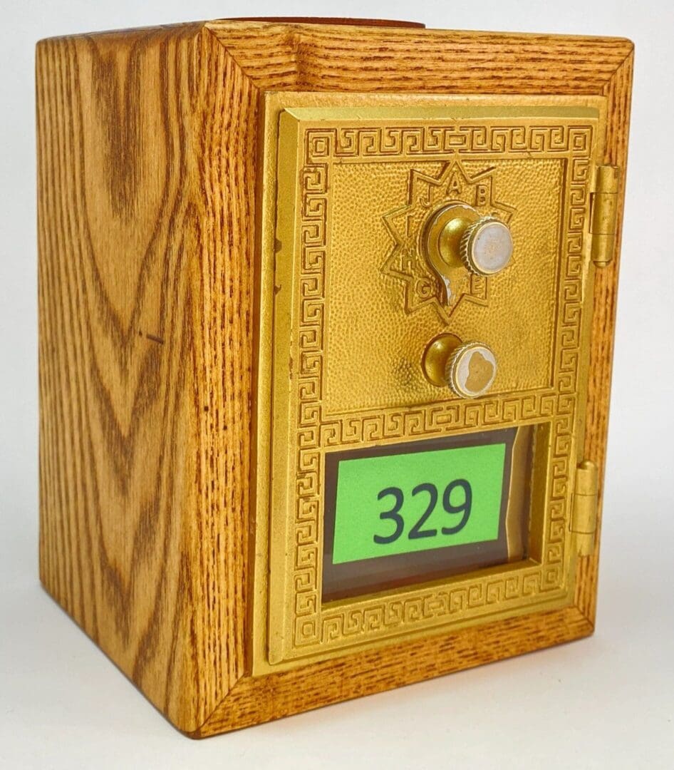 A wooden box with a gold door and the number 3 2 9.