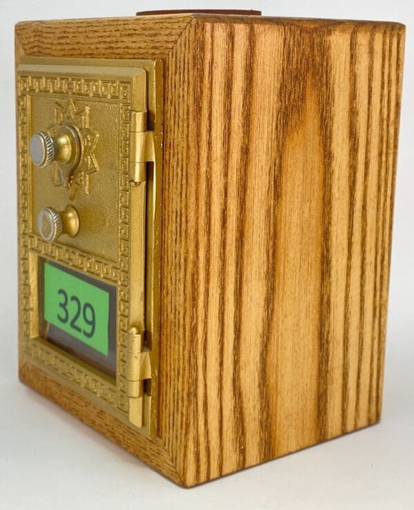 A wooden box with a gold door and numbers on it.