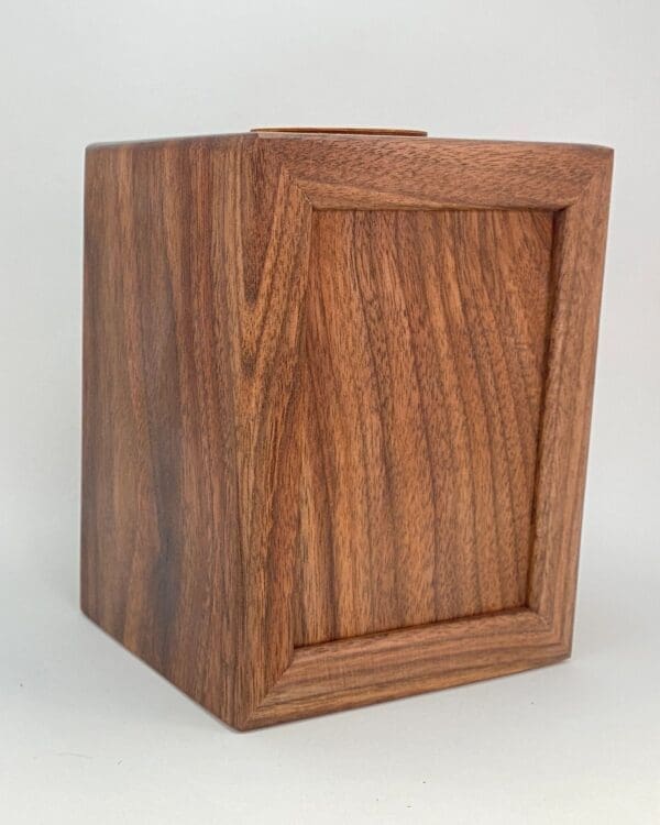 A wooden box with a small window on the side.