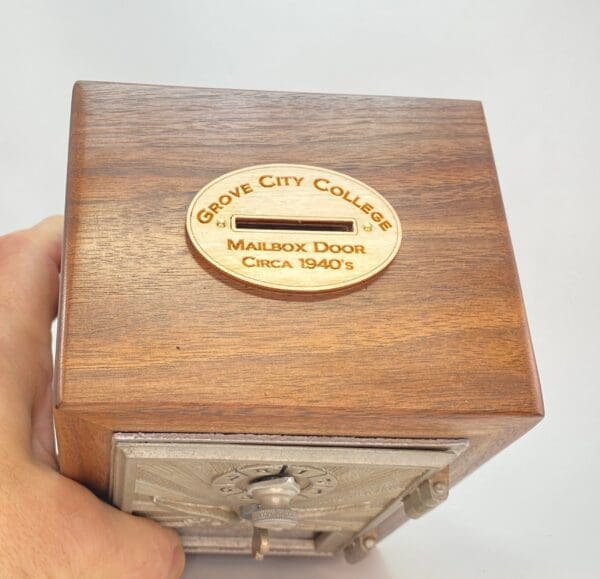 A hand holding onto the side of a wooden box