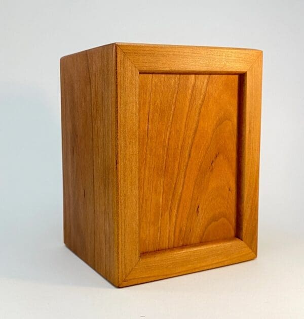 A wooden box with a small window on the side.