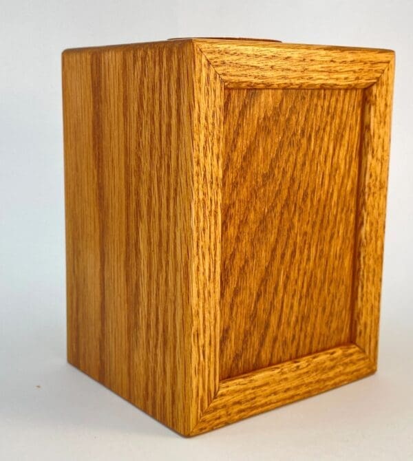 A wooden box with a small square opening.