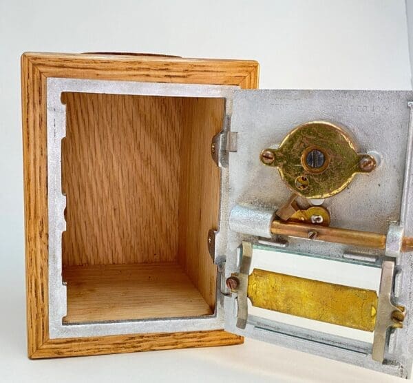 A wooden box with a gold and silver piece of art inside.