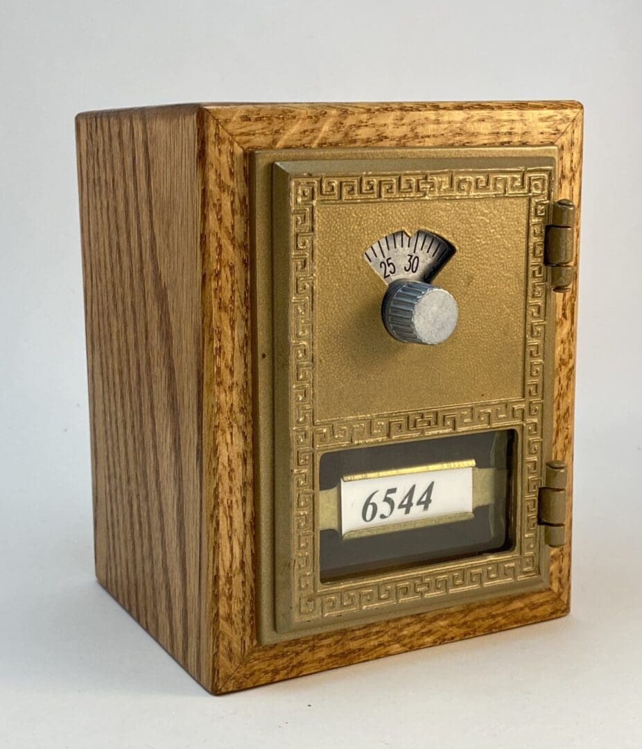 Wooden framed antique brass mailbox.