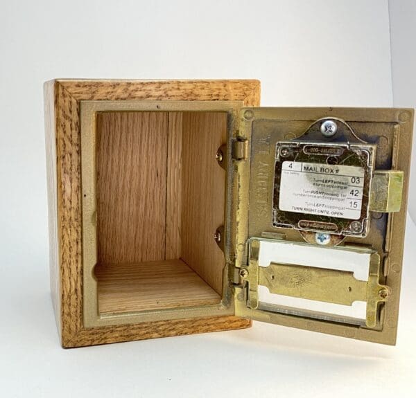 Wooden mailbox with brass door open.