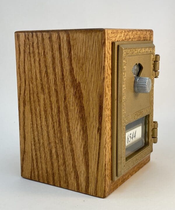 Wooden mailbox with brass door and number 6544.