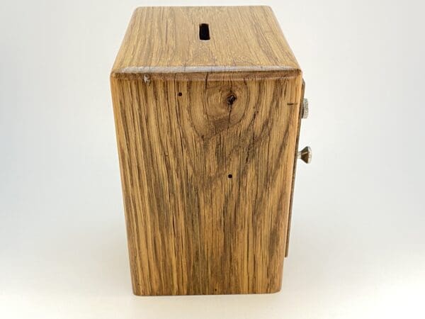 Wooden piggy bank with a coin slot.