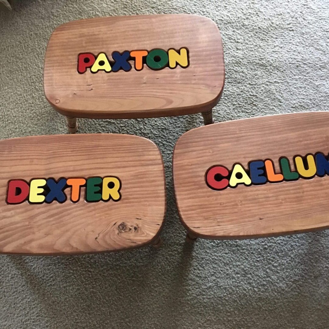 Three wooden stools with the names of people.