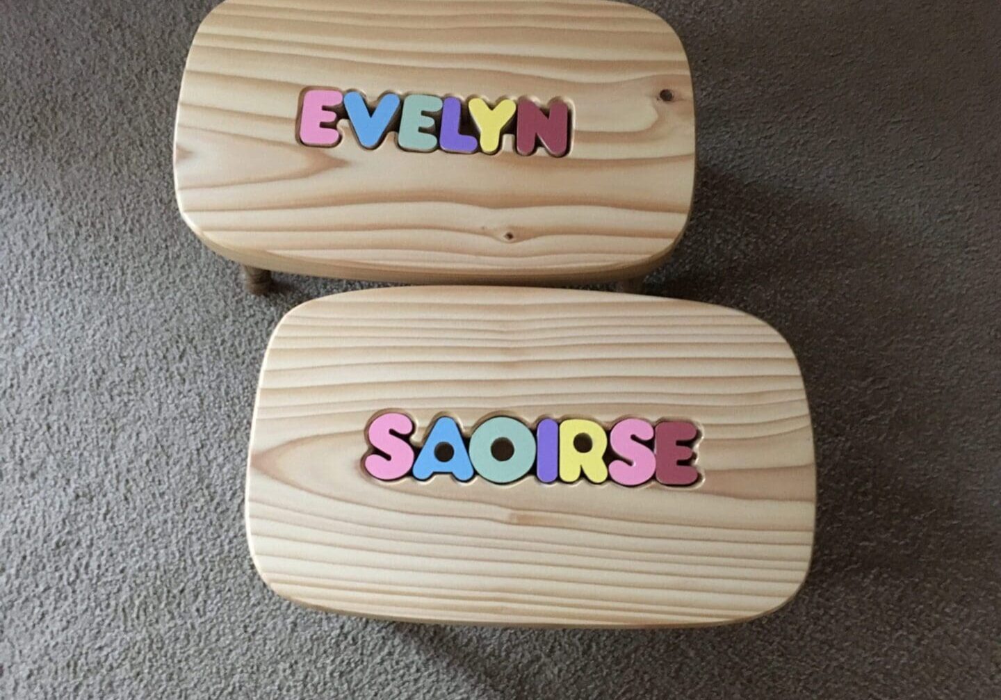 Two wooden stools with letters on them.